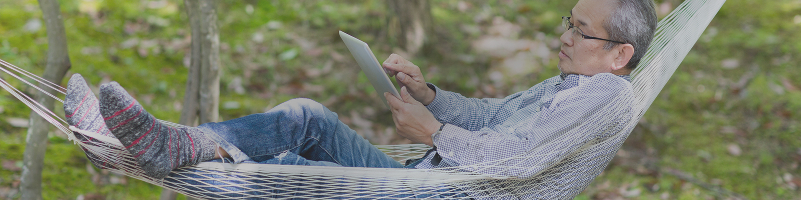 Man calculating finances while in hammock