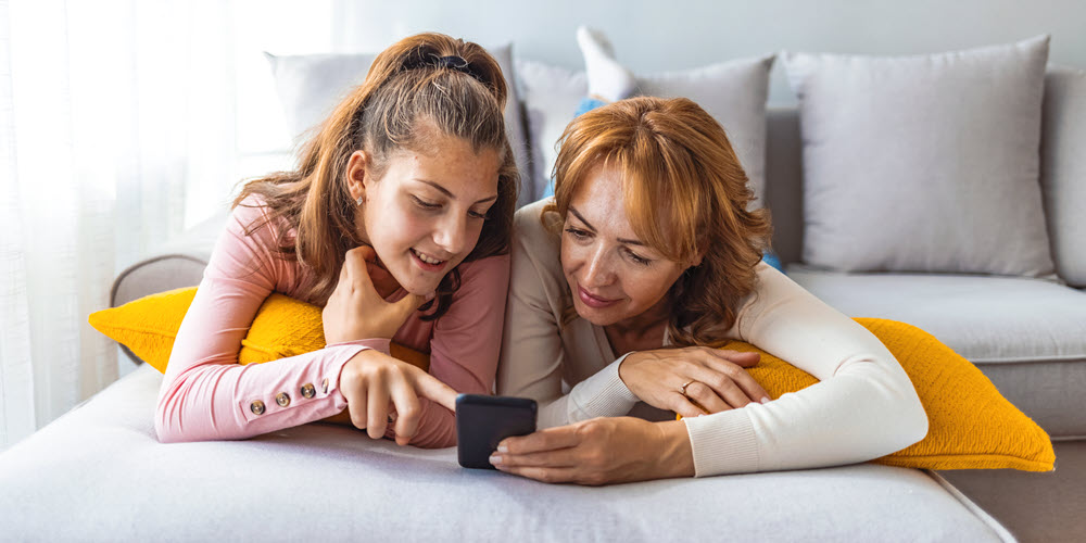 Mom reviewing banking app with daughter.