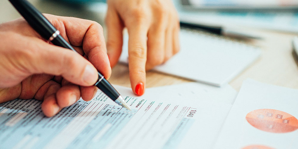 Two people filling out a tax form 1040