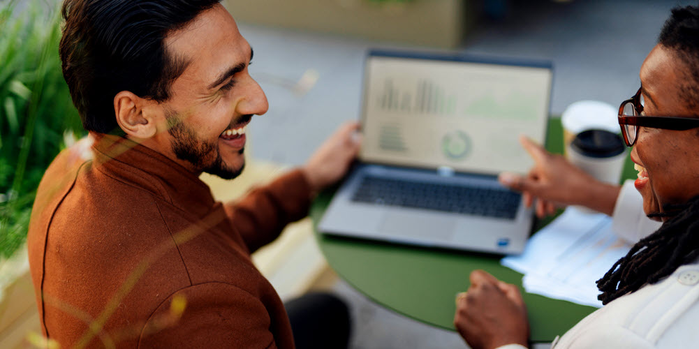 Man and woman smiling looking at laptop computer