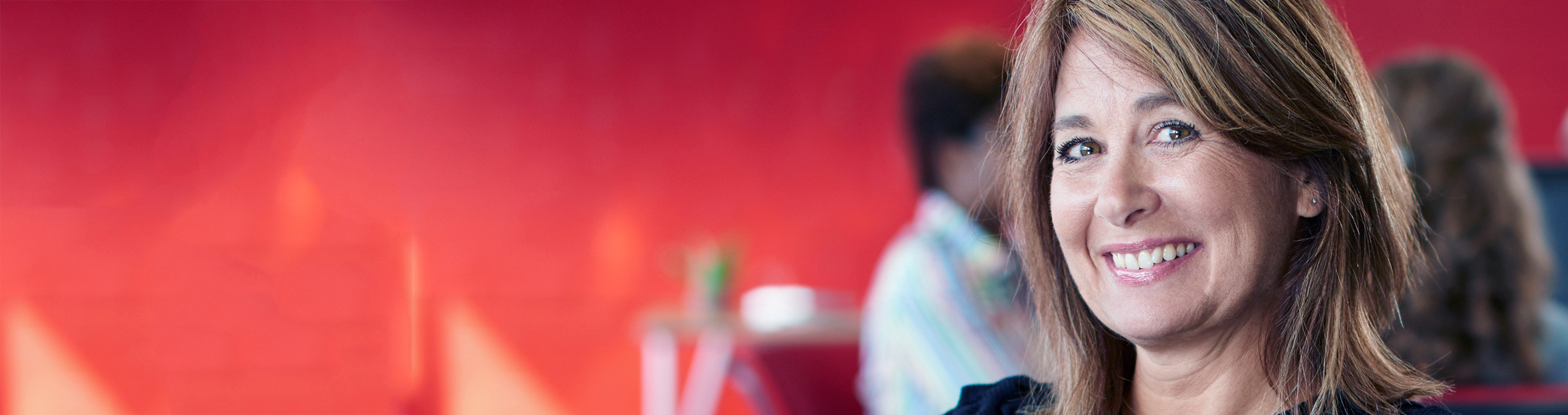 Smiling woman sitting in a public setting