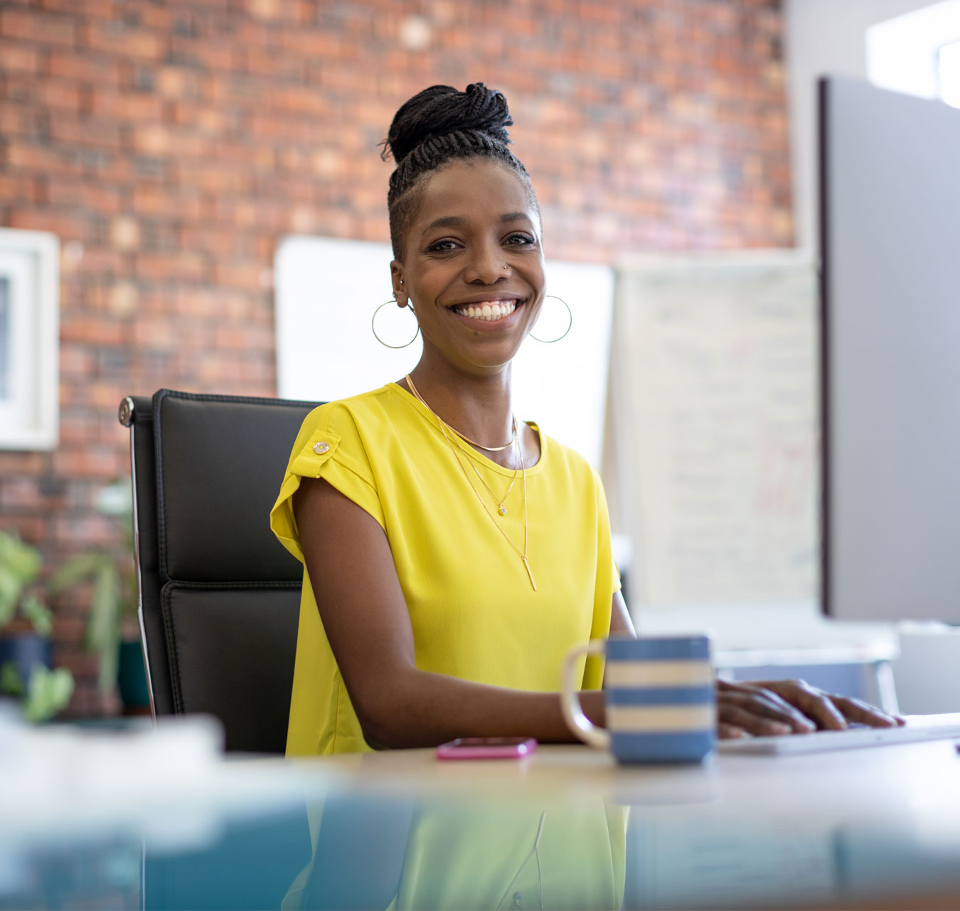 Professional woman sitting in a cheerful office and smiling.