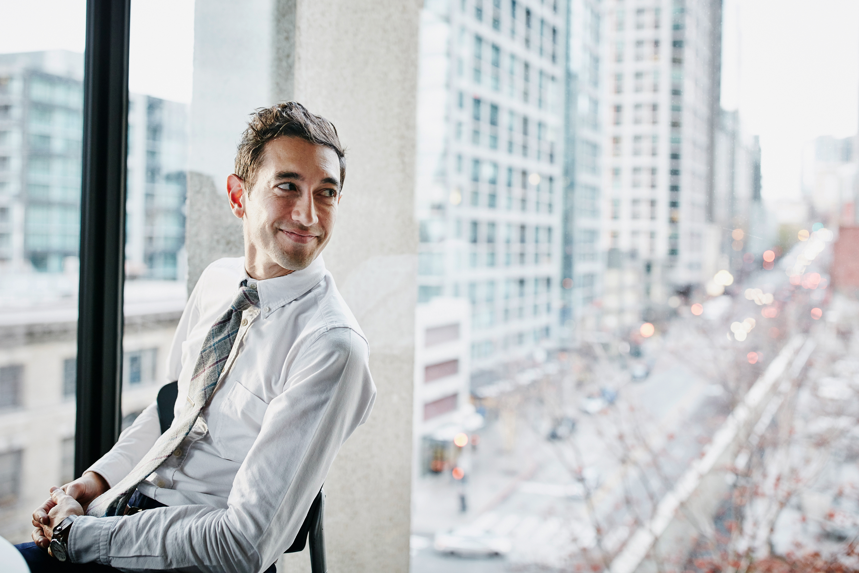 Man in business casual attire looking over shoulder in office.