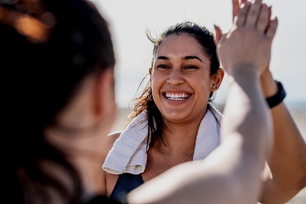 Woman high fiving work out partner.